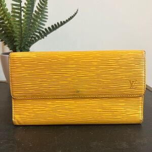 This is a yellow  (golden) Louis Vuitton Epi leather wallet.